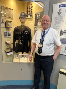 Image shows the curator of the Police Museum alongside one of the exhibits